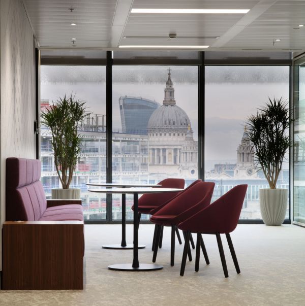 Modern office seating area with cityscape view through large windows.