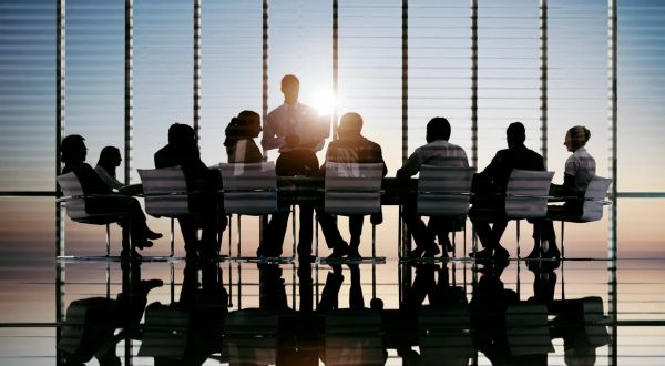 Business meeting silhouettes in a conference room at sunset.