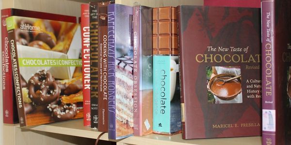 A bookshelf with various chocolate-themed cookbooks.