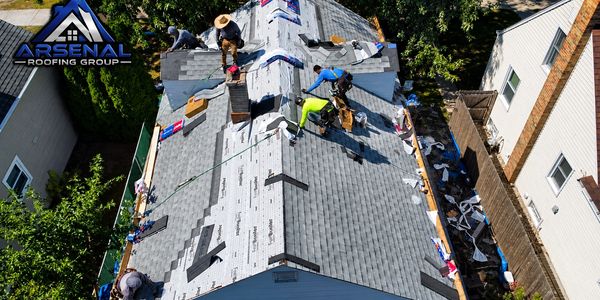 Roofers installing shingles on a residential roof.