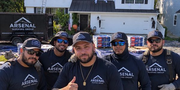 Group of roofing workers posing outdoors.
