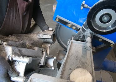 Alugussteil entgraten an industrieller Bandschleifmaschine von IMM