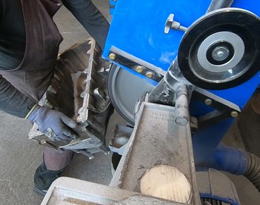 Aluminiumguss Bauteil beim Bandschleifen zur Gratentfernung