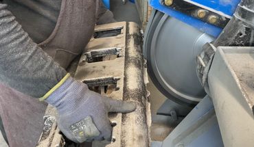 Alugussteil mit Gratbildung beim Schleifen auf Bandschleifmaschine