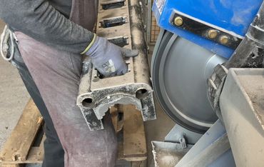 Entgraten von Aluminiumgussteilen mit stationärem Schleifband