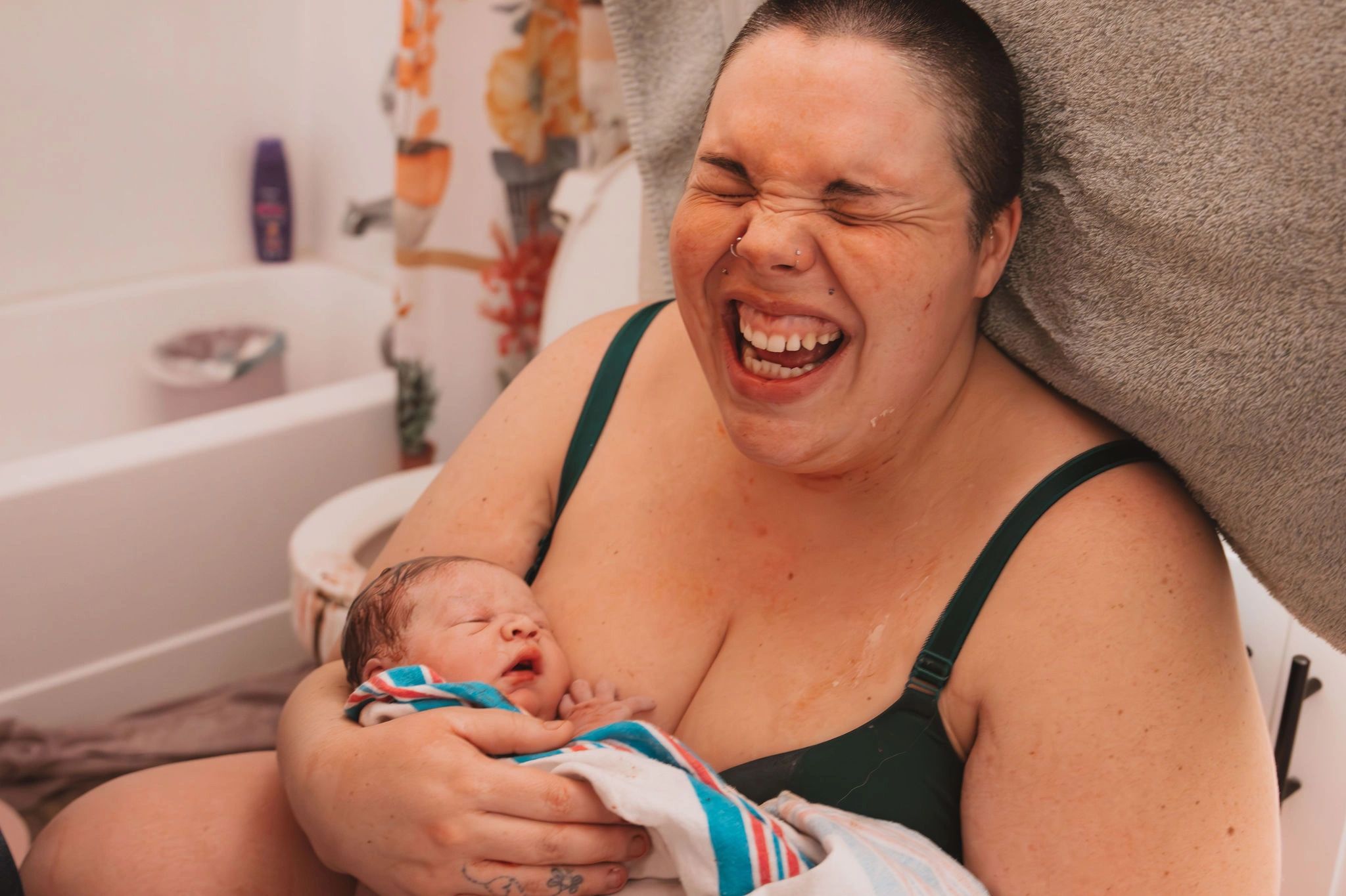 Photo of a widely smiling client just after birth by Hannah Blauser Photography @hannahblauserphoto