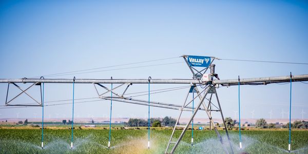 Valley 7000 series machine spraying a field, rainbow refraction from water being sprayed.
