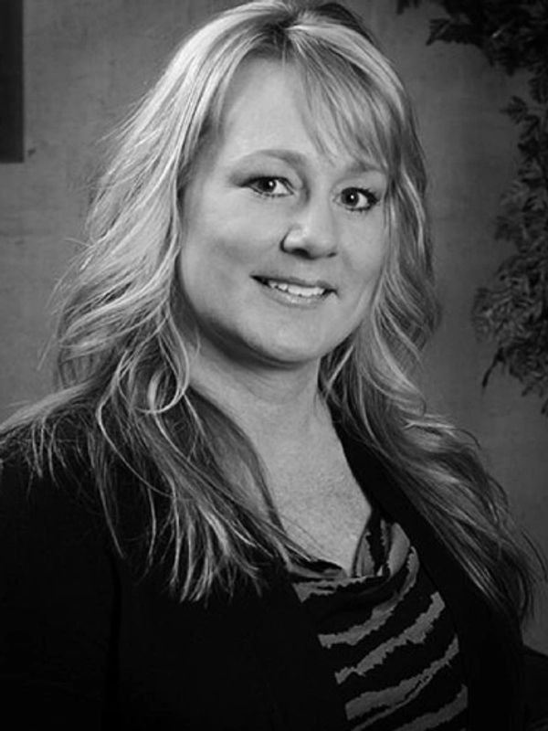 Black and white portrait of a smiling woman with long hair.