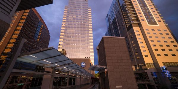 Modern skyscrapers reflecting sunset light in an urban cityscape.