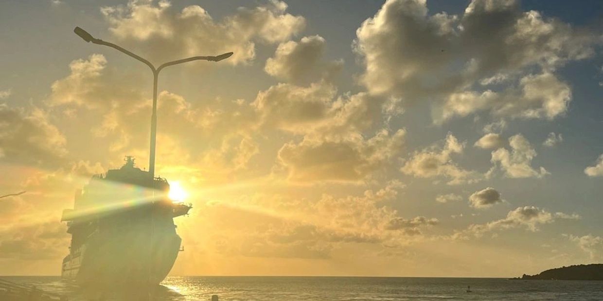 Sunset behind a ship with street lamps creating a unique silhouette.