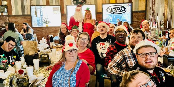 Group celebrating Christmas with festive hats and decorations.