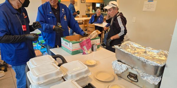 Volunteers preparing food for distribution in a community setting.
