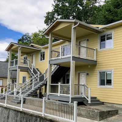 Chehalis quadplex with new composite porches, covered decks, and railing by local builder.