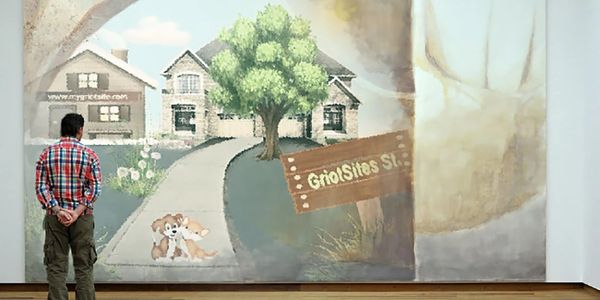 man standing in front of GriotSites mural