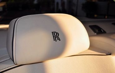 Close-up of a Rolls-Royce headrest with logo.