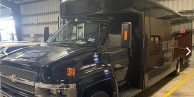 Black delivery truck parked inside a warehouse.
