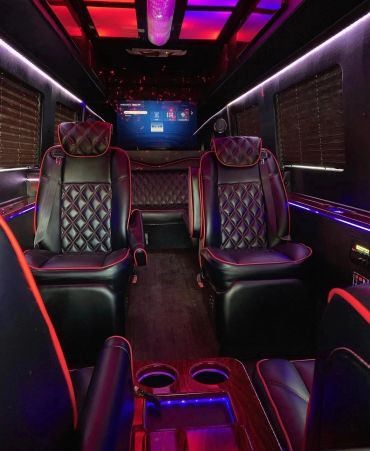 Luxurious van interior with black leather seats and ambient lighting.
