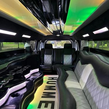 Luxurious limousine interior with leather seats and colorful lighting.