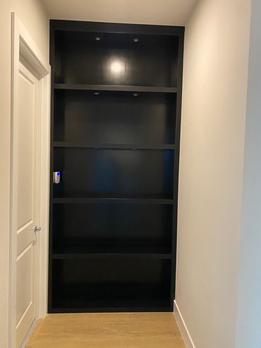 Empty black built-in shelves in a narrow hallway.