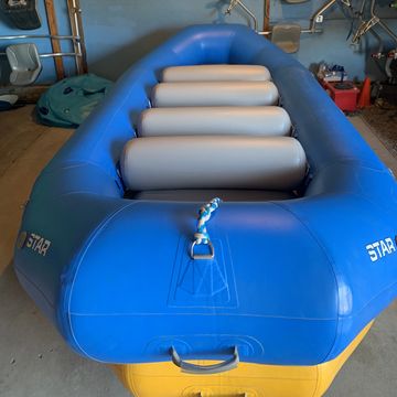 Blue inflatable raft with gray seats in garage.