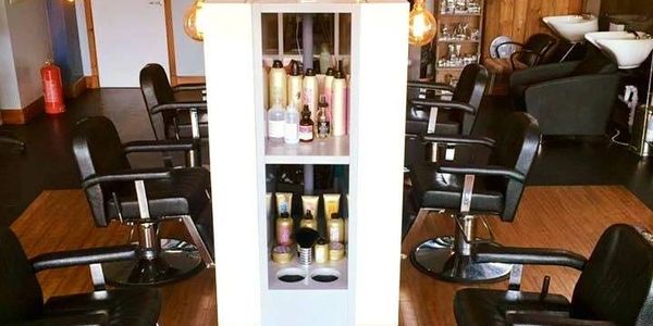 An empty hair salon with chairs and hair products.