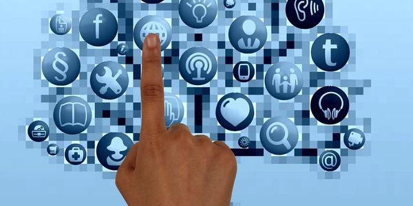 Person pointing on a social media icon on a display