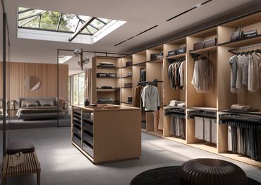 Modern walk-in closet with wooden shelves and natural light from skylight.