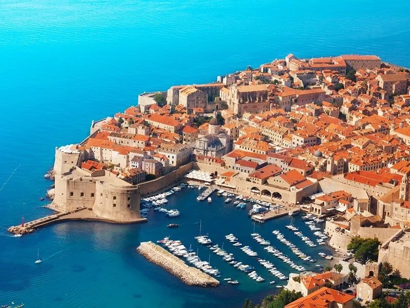 Black and white image of Dubrovnik Croatia Old Town and Marina with boats in the Adriatic Sea