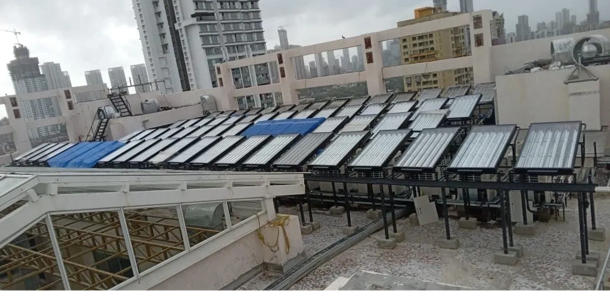Solar water heaters installed on a building rooftop in an urban area.