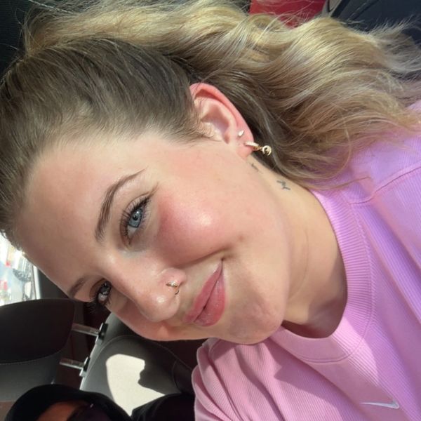 Smiling woman with blue eyes and pink shirt.