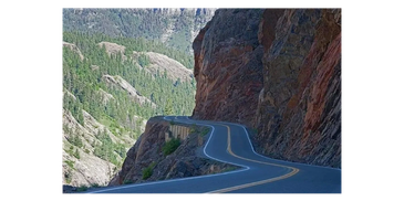 Winding mountain road hugging the rocky cliff.