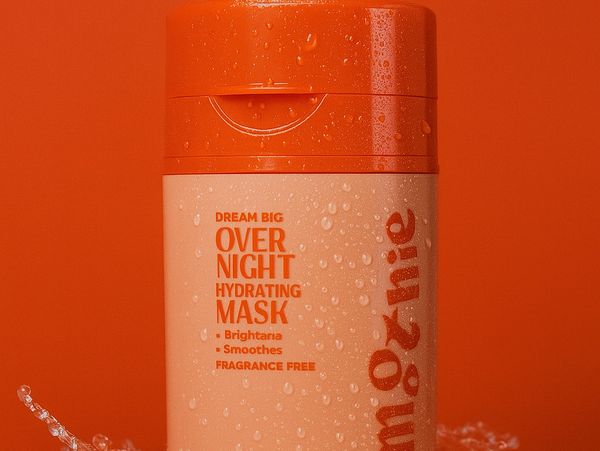 Close-up of an orange hydrating mask bottle with water droplets.