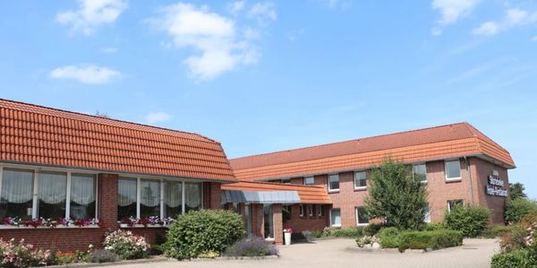 Gebäude mit rotem Ziegeldach unter blauem Himmel.