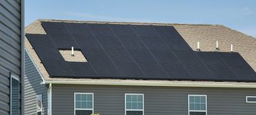 Solar panels installed on a house roof with a missing panel section.