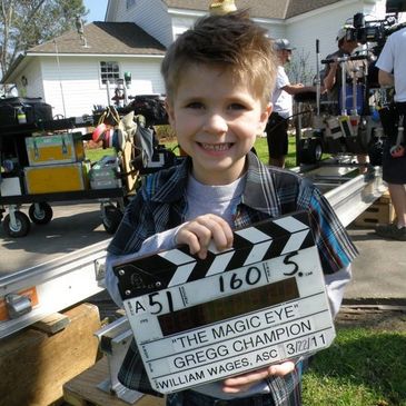 Little boy holding clapboard on set. Go to Kids & Teens On-Camera Acting Class
