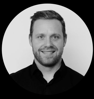 Portrait en noir et blanc d'un homme souriant.