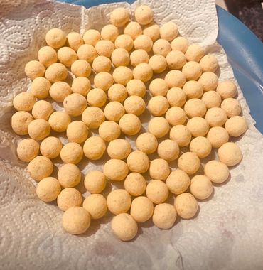 Small round orange balls arranged on a paper towel.