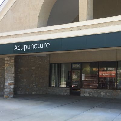 Exterior of Blue Valley Acupuncture Clinic with overhead sign and front door