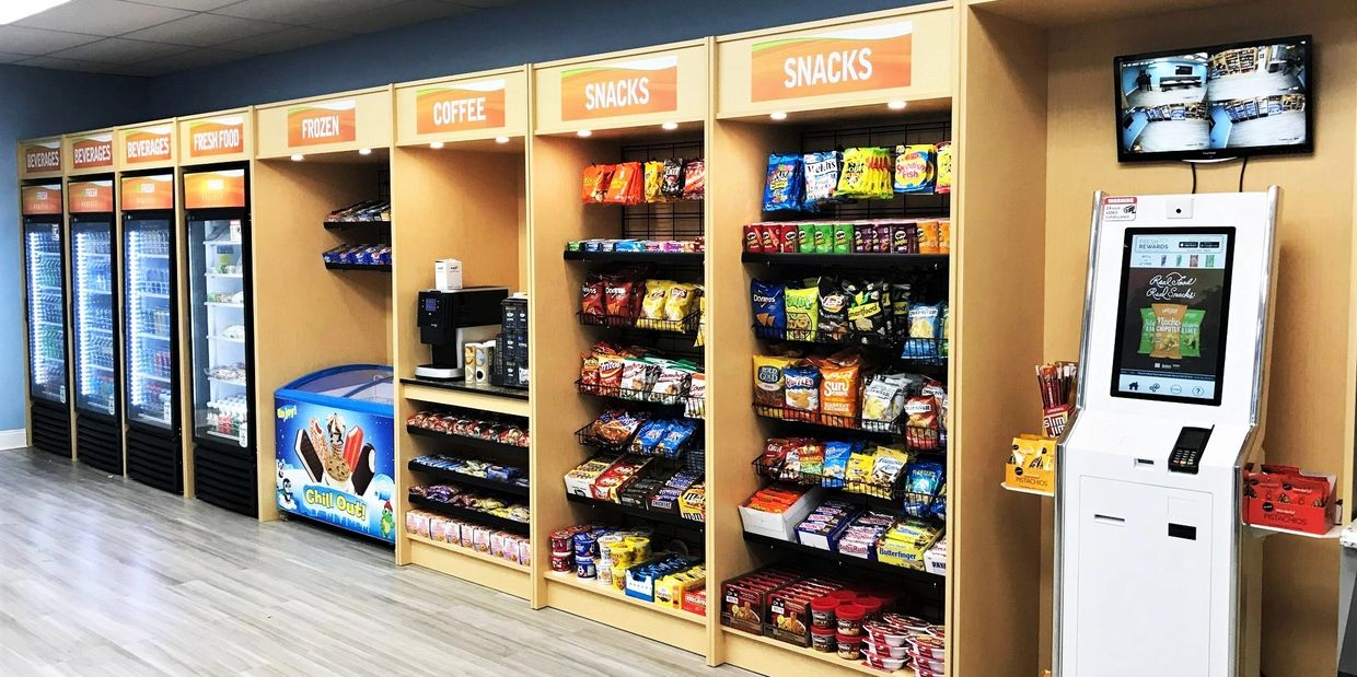Modern convenience store with beverages, snacks, coffee, and a self-checkout kiosk.