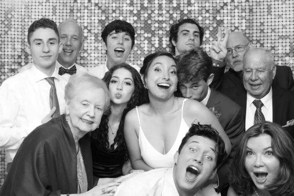 Couple and wedding guests posing with props in a Hudson Valley photo booth by Zaro's Photo Booth.