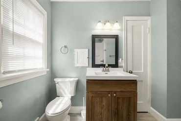 Bathroom remodel with new vanity installation, lighting, flooring replacement, and finish work.