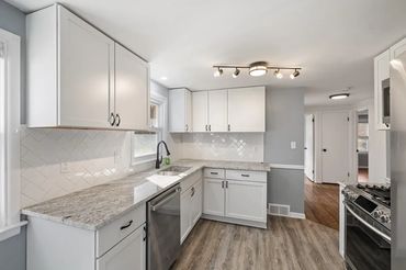 New Kitchen remodel with granite countertops, wood flooring, and tile backsplash.