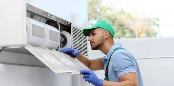 Technician inspecting air conditioner filter.