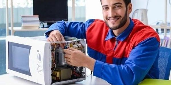 Technician repairing a microwave oven.