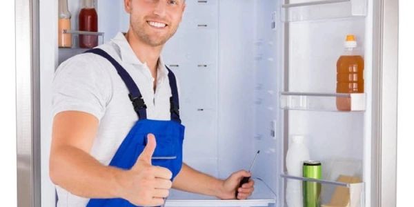 Technician giving thumbs up with open refrigerator.