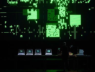 Person operating vintage computers with green digital display.