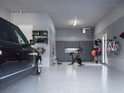 A clean, organized garage with a car, exercise bike, and wall-mounted bicycle.