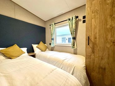 Cozy bedroom with twin beds and floral curtains.