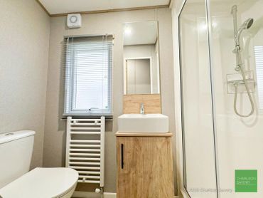 Modern bathroom with a toilet, sink, and shower.