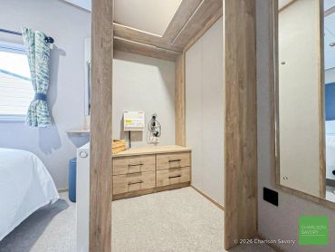 Small wooden storage unit with drawers in a carpeted room.